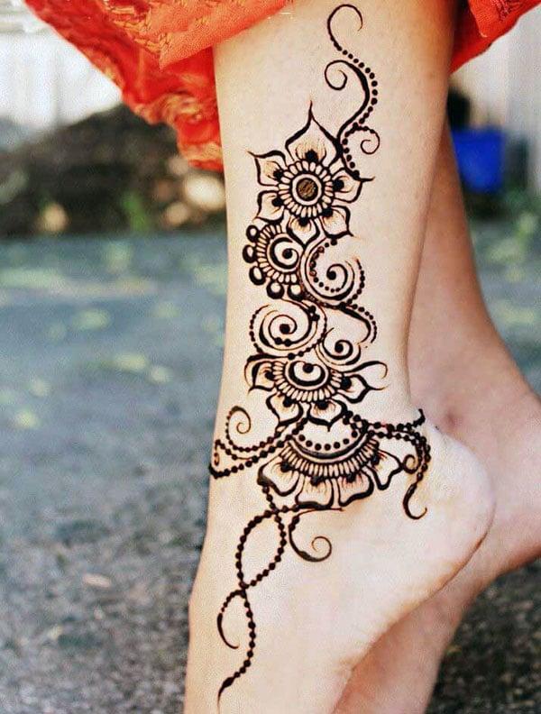 Glamorous mehendi design on woman’s ankle 