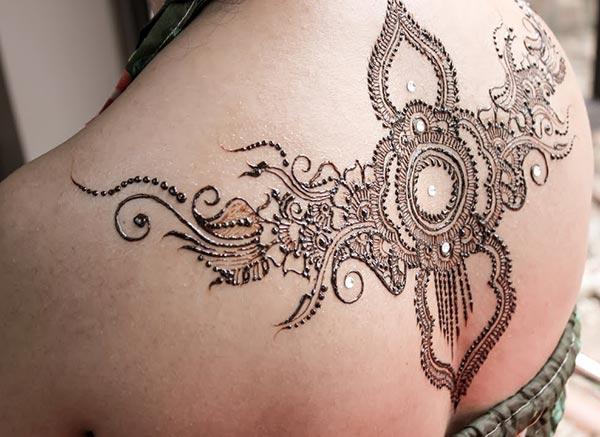An ornamental shoulder back mehendi design for Women henna lovers
