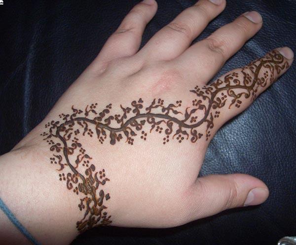 A creeper mehendi design on back hand for Women