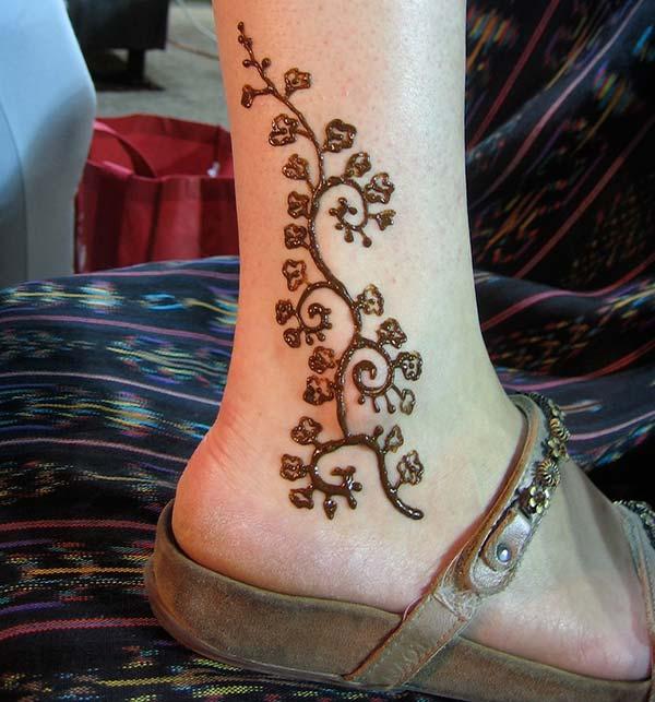 A curly love on the ankle of a lady using mehendi design