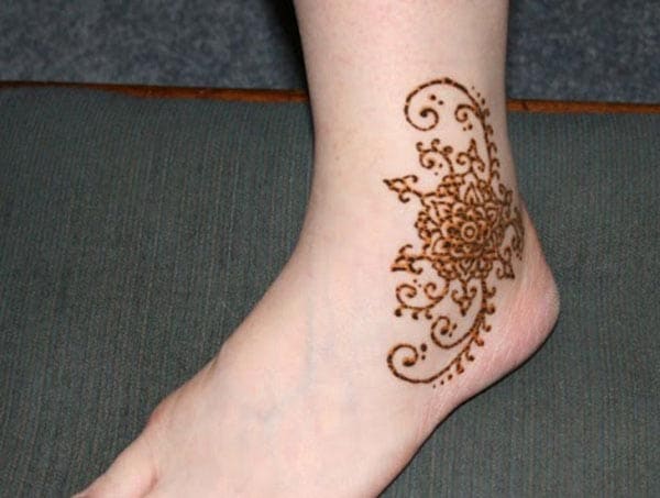 A bold floral mehendi design on ankle for Women