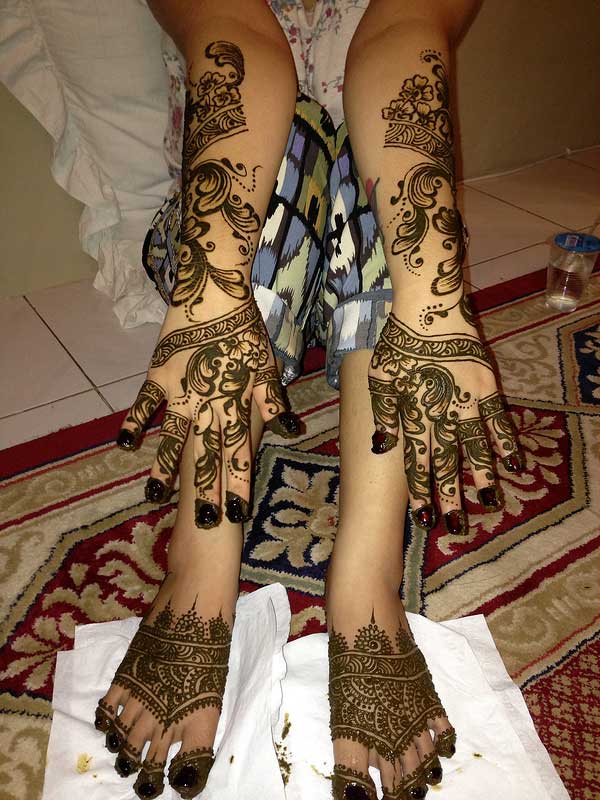 Flower and spirals hand and leg mehendi design for brides