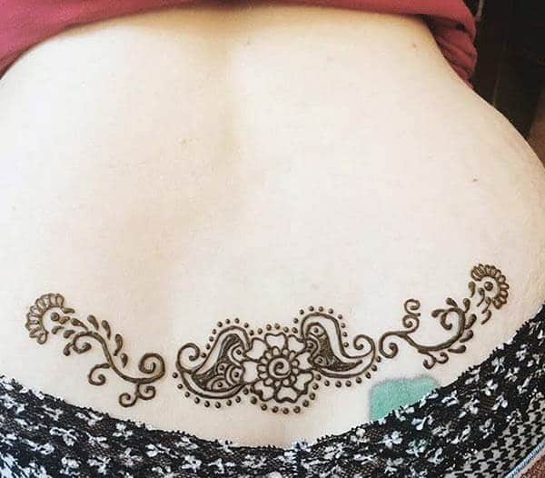 A small band of mehendi design on lower back for Girls and women