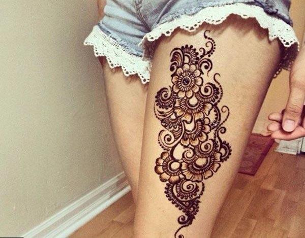 An eye-catchy flower power mehendi design on thigh for Ladies