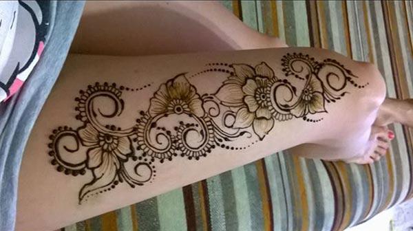 An arresting floral love mehendi design on thigh for Ladies
